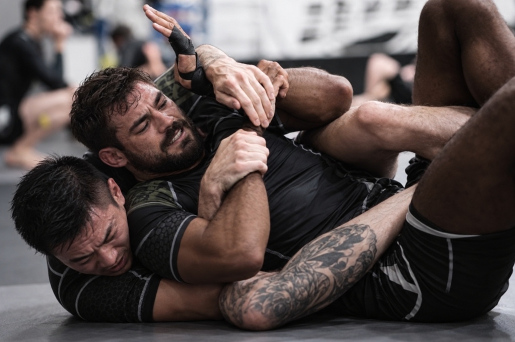 Two collegiate grapplers in intense action on the mat